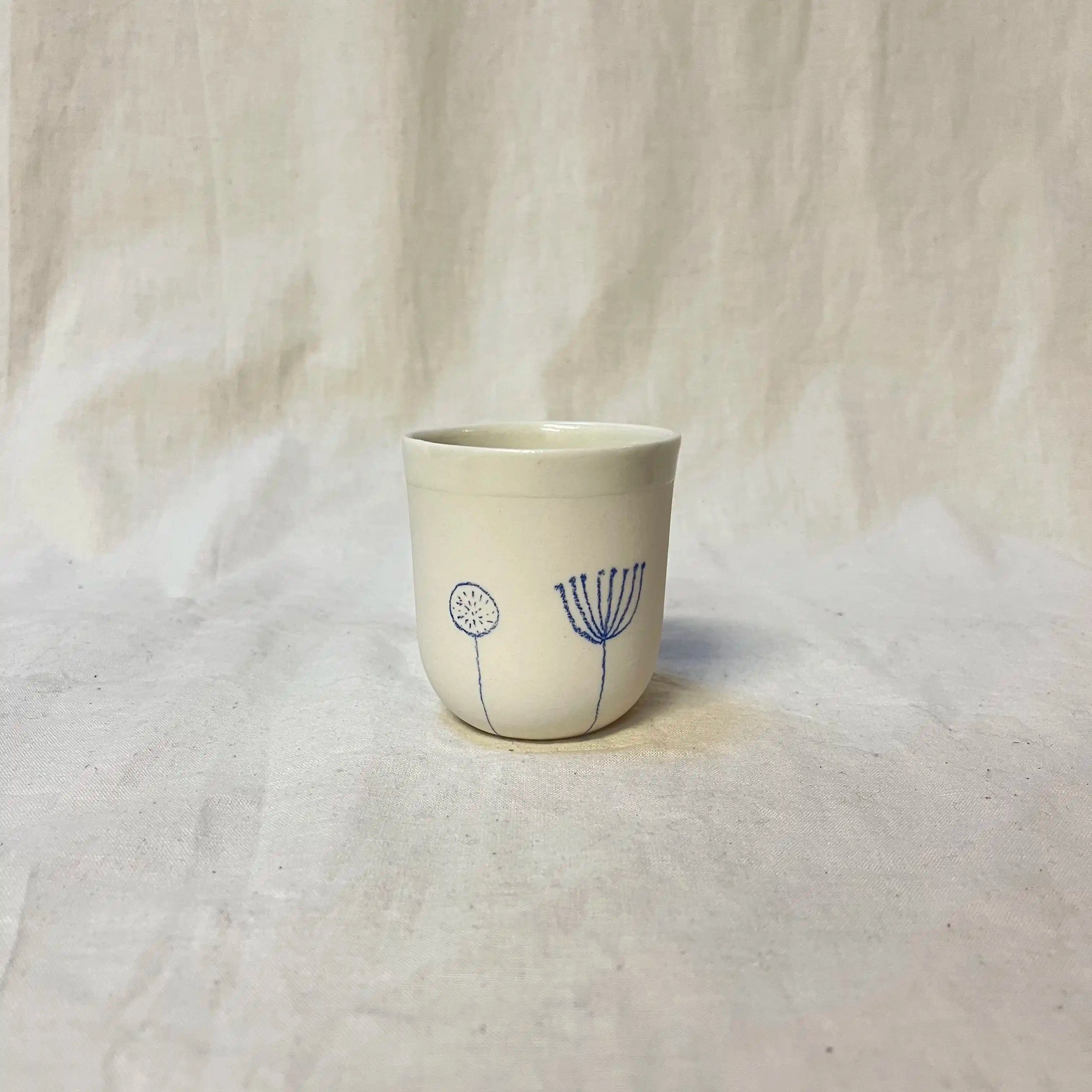 Tasse porcelaine moulée. Diamètre 6,5cm, hauteur 7 cm. Émail intérieur, décor au crayon à oxydes