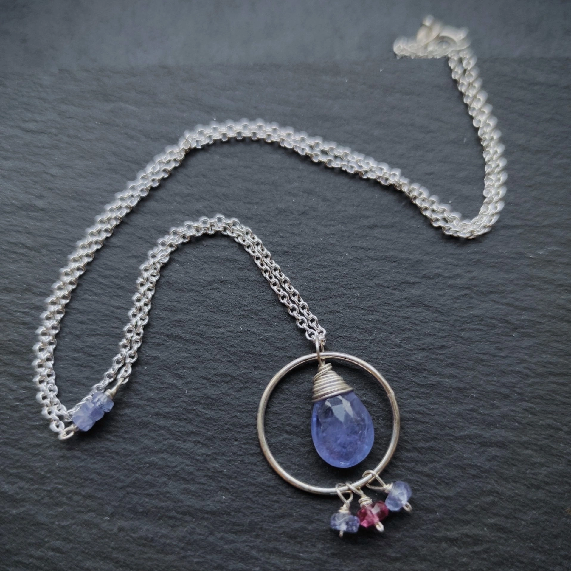 Collier argent fluide et léger composé de tanzanites et d’une petite tourmaline rose.